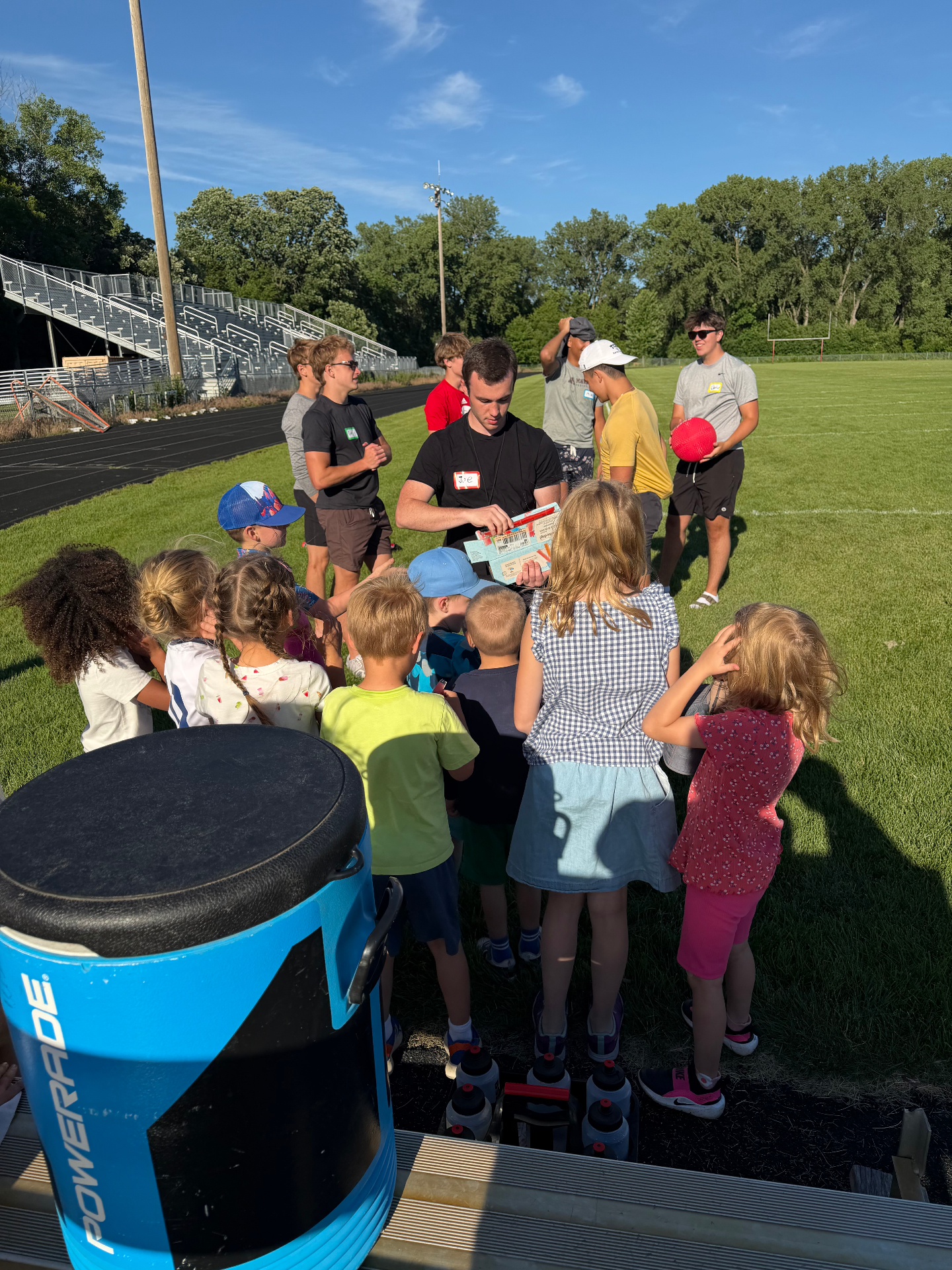 Joe handing out ice pops to kids at an Athletes for Action camp